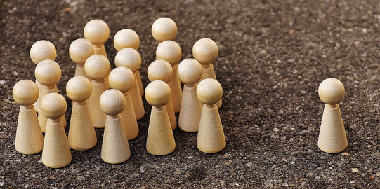 Spielfiguren Gruppe Holzspielfiguren mit einer alleinstehenden Figur als Gruppenleiter