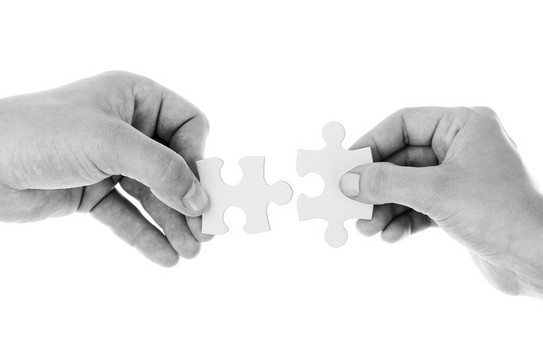 Zwei Hände verbinden zwei Puzzleteile