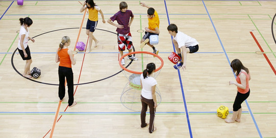 Turnhalle Kinder in einer Turnhalle, die mit übergroßen Schaumstoffwürfeln Übungen machen